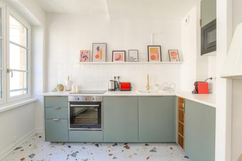 a kitchen with blue cabinets and a sink at Design et cosy en hypercentre in Lyon