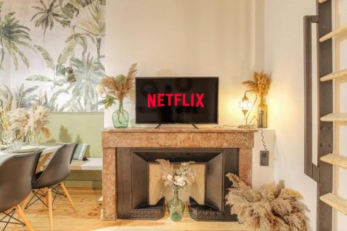 - une télévision au-dessus d'une cheminée dans le salon dans l'établissement Le Raffiné avec Caractère en hypercentre, à Lyon