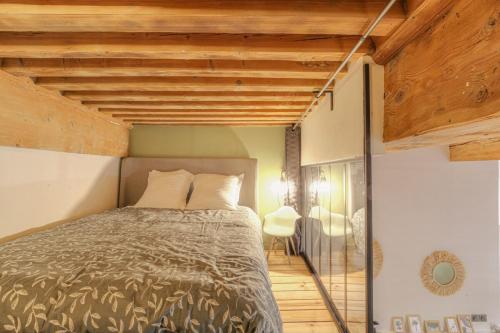 een slaapkamer met een bed en een houten plafond bij Le Raffiné avec Caractère en hypercentre in Lyon