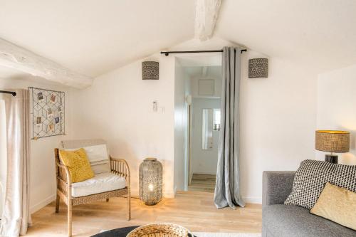 a living room with a couch and a chair at Le chaleureux et cosy avec parking proche Lyon 