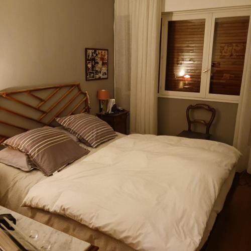 um quarto com uma grande cama branca e uma janela em OREE DE MARLY em Noisy-le-Roi