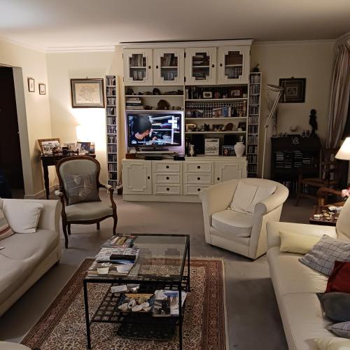 uma sala de estar com mobiliário branco e uma televisão em OREE DE MARLY em Noisy-le-Roi