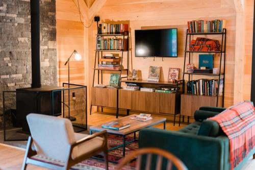 a living room with a couch and a tv at Huttopia Adirondacks in Lake Luzerne