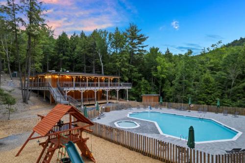 a resort with a swimming pool and a building at Huttopia Adirondacks in Lake Luzerne