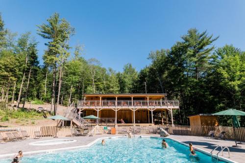 a pool at a resort with people in the water at Huttopia Lake George - Adirondacks in Lake Luzerne