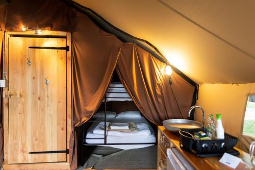 a room with a tent with beds in it at Huttopia Lake George - Adirondacks in Lake Luzerne
