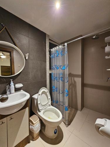een badkamer met een toilet, een wastafel en een douche bij Departamentos frente al mar Resort Playa Azul in Tonsupa
