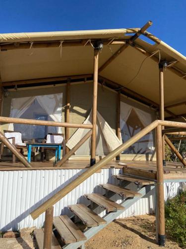 a building with a tent with a table in it at למדבר- חווית גלמפינג במדבר in Arad