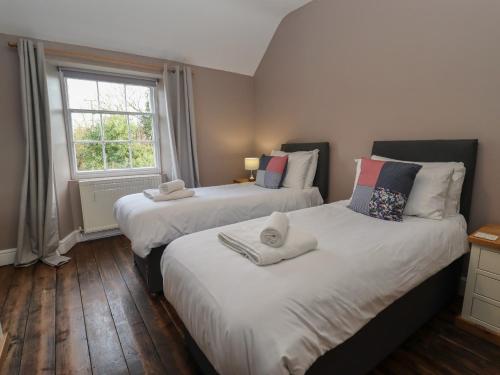 two beds in a room with a window at Wayside House in Craven Arms