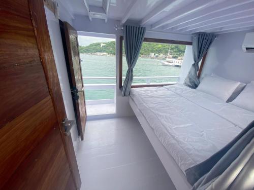 Cama pequeña en un barco con ventana en William Komodo Travel, en Nggorang