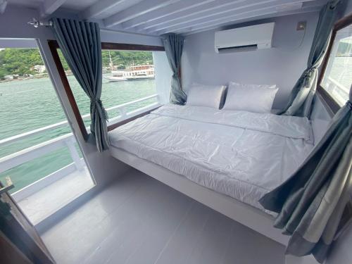 una cama en la parte trasera de un barco en William Komodo Travel, en Nggorang