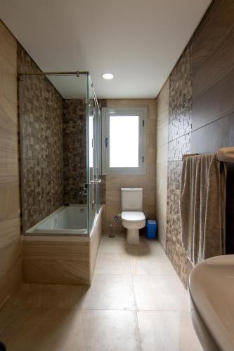 a bathroom with a tub and a toilet and a sink at Luxurious NEW CAIRO Mirage City 1 BRD Apartment in Cairo