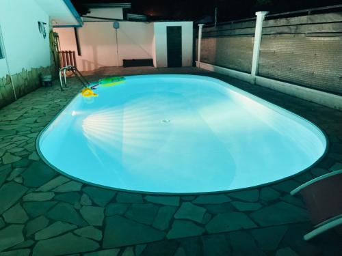 a large swimming pool in a building with a blue pool at Sermie T2 climatisé avec piscine in Kourou