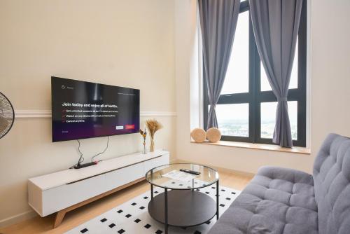 a living room with a tv and a couch and a table at Sunway Grid Loft Suite by Nest Home【Olympic Size Pool】 in Kampong Pendas