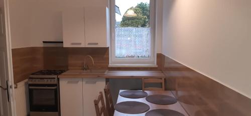 a kitchen with a counter with a sink and a window at Górski Zakątek in Meszna