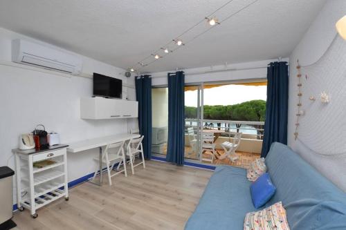 ein Wohnzimmer mit einem blauen Sofa und einem Tisch in der Unterkunft La lagune vue canal et accès mer in Le Grau-du-Roi