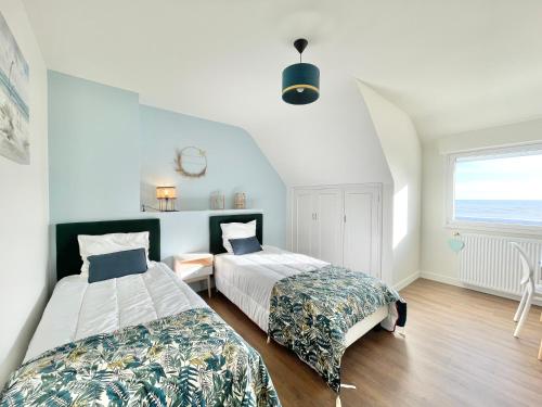 une chambre avec deux lits et une fenêtre dans l'établissement VILLA BREIZH RIVIERA - La plage au bout du jardin !, à La Forêt-Fouesnant