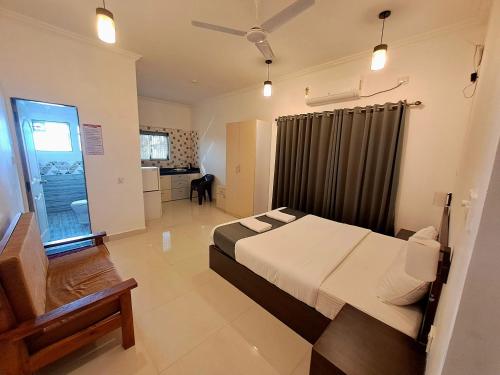 a large bedroom with a bed and a kitchen at Hotel RSA Residency in Pernem