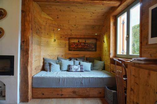 Bett in einem Blockhaus mit Fenster in der Unterkunft Bellissimo appartamento a Pinzolo in Pinzolo