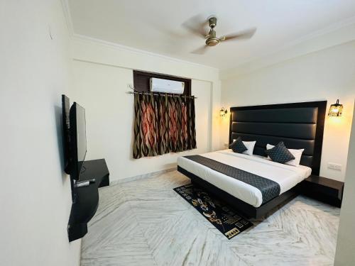 a bedroom with a bed and a flat screen tv at Sheela Homestay in Agra