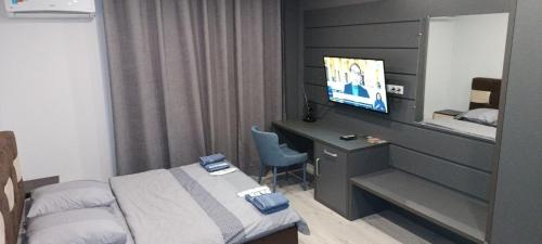 Habitación de hotel con cama y escritorio con TV. en VIP Apartments 35 en Úzhgorod