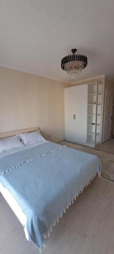 um quarto com uma cama com um cobertor azul em Однокомнатная квартира в административном центре em Türkistan