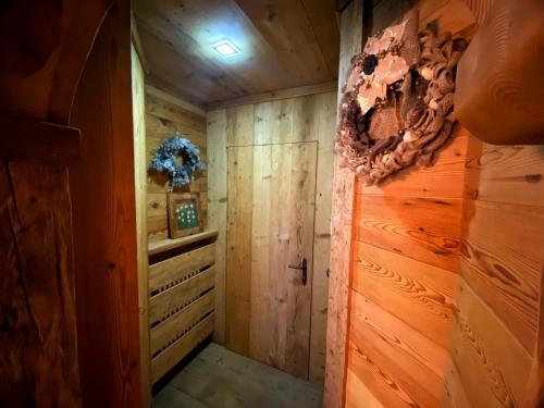 a walk in shower in a cabin with wood paneling at Bellissimo appartamento a Pinzolo in Pinzolo