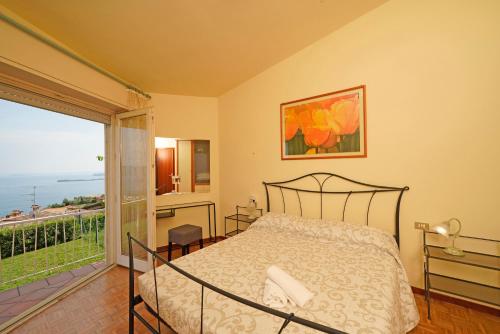 - une chambre avec un lit et une vue sur l'océan dans l'établissement Villa Laura, à Toscolano Maderno