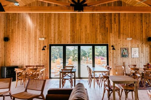 a room with wooden walls and tables and chairs at Huttopia Wine Country in Lower Lake