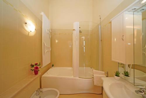 La salle de bains est pourvue d'une baignoire, d'une douche et d'un lavabo. dans l'établissement Villa Laura, à Toscolano Maderno