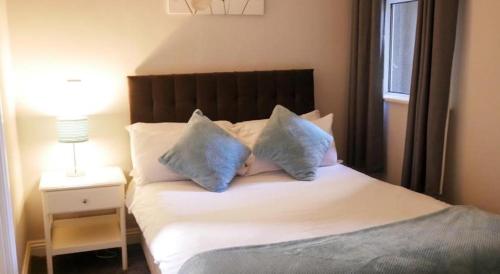 a bedroom with a bed with blue pillows on it at Eurostar Budget Rooms - Next to Kings Cross & Eurostar Train Station in London