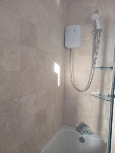 a bathroom with a shower with a tub and a sink at Silvertree Lodge - 2 double bed flat with parking in Hemel Hempstead
