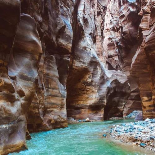 a pool of water in a slot canyon at - Trekking from Dana to Petra in Dana