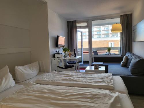 - une chambre avec un lit et un salon dans l'établissement Apartment 35 im Haus Villa Anna, à Sankt Peter-Ording