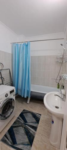 uma casa de banho com uma máquina de lavar roupa e um lavatório em Однокомнатная квартира в административном центре em Türkistan