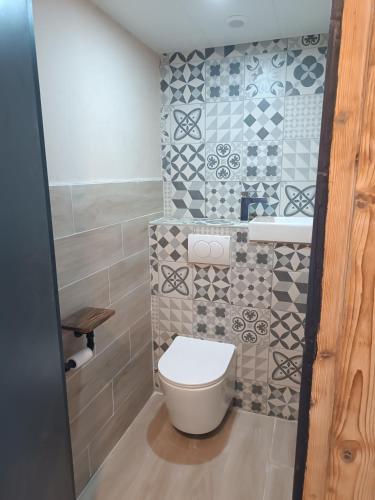 a bathroom with a toilet and a sink at Chambre Les étoiles de Bevy in Molunes