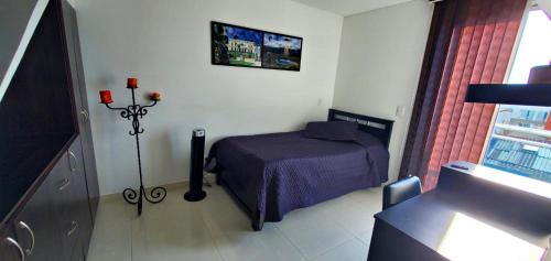 1 dormitorio con 1 cama y TV en la pared en EXCELENTE CONJUNTO, UBICACION PRIVILEGIADA,, en Armenia