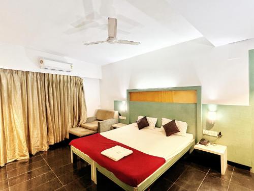 a bedroom with a large bed and a couch at Hotel Twins Residency in Thane