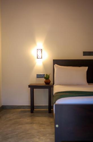 a bedroom with a bed and a table with a clock on the wall at Ran Villa in Hiriketiya
