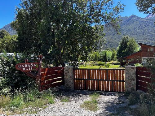 a wooden fence with a sign in front of a house at Rio Manso cabaña km 18 in Río Villegas