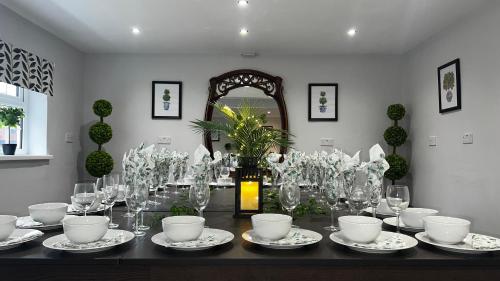 a table with glasses and plates on it at The Cheshire Gathering - With Hot Tub in Chester
