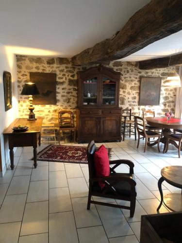 - un salon avec des chaises, des tables et des murs en pierre dans l'établissement La Maison Rose, à Viévy