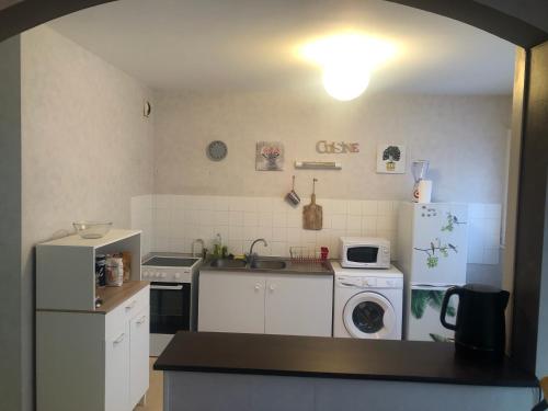 une cuisine avec un réfrigérateur et une machine à laver dans l'établissement Appartement T2 meublé, à Limoges