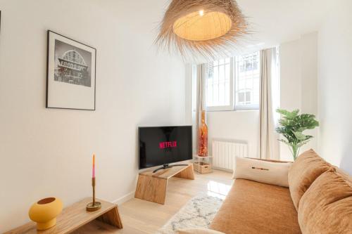 un salon avec un canapé et une télévision dans l'établissement Charmant et cosy en hypercentre, à Lyon