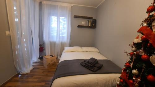 una habitación con un árbol de Navidad y una cama en Ski House Marmotta en Borgata Sestriere