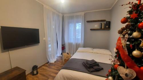 - une chambre avec un arbre de Noël et un lit dans l'établissement Ski House Marmotta, à Borgata Sestriere