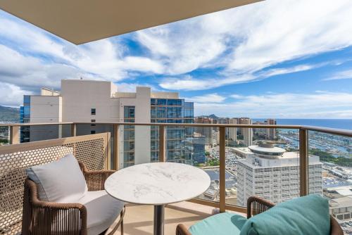 d'un balcon avec une table et des chaises offrant une vue sur la ville. dans l'établissement Sky Ala Moana 4005 condo, à Honolulu