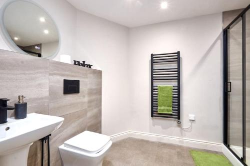 y baño con aseo, lavabo y espejo. en Comfortable Leeds Flat - Ideal For Long Stays en Leeds