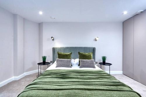 a bedroom with a large green bed with two tables at Comfortable Leeds Flat - Ideal For Long Stays in Leeds