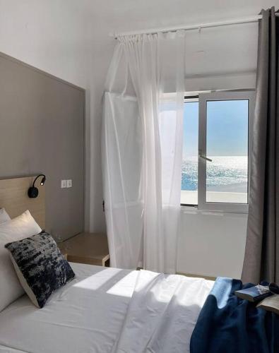 a bedroom with a bed and a large window at VistaMare2 Double room-sea view in Koutsourás